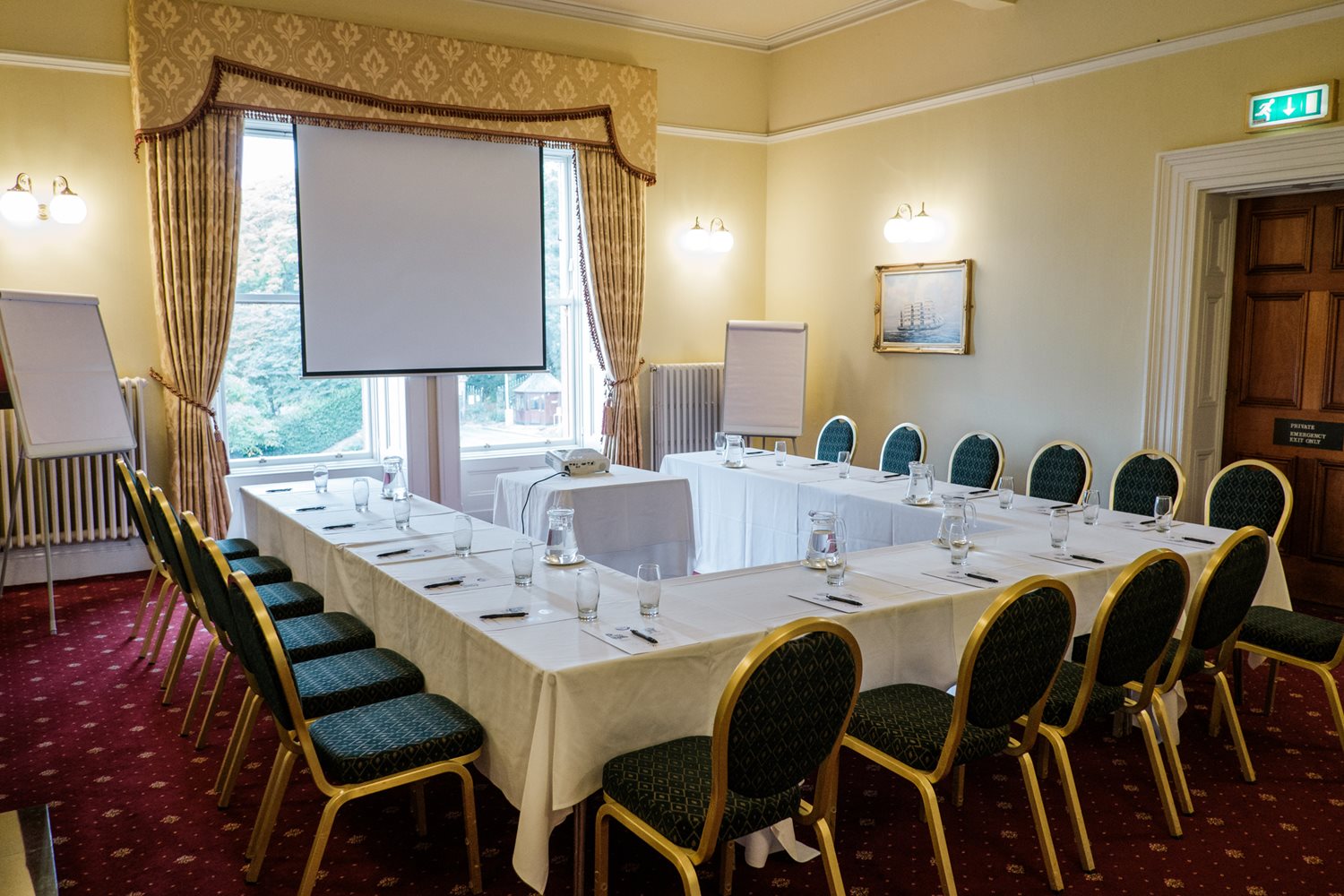 Ashley Room with a large table and chairs and screen in a u-shape style setup..